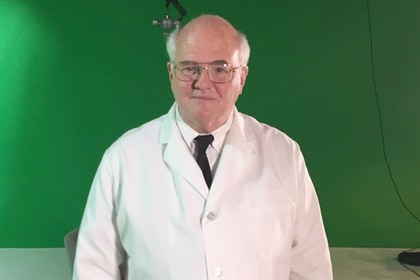 Michael Kelcourse stands in front of a green screen in his butler uniform