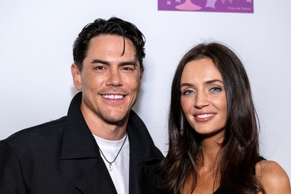 Tom Sandoval and Victoria Lee Robinson posing in front of a step and repeat.