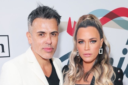 Teddi Mellencamp and Edwin Arroyave posing in front of a step and repeat.