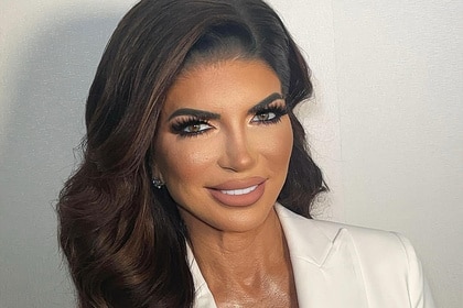 Teresa Giudice smiling in front of a wall.