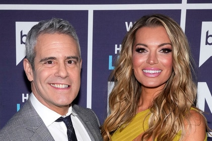 Andy Cohen and Lindsay Hubbard pose together in front of a step and repeat.