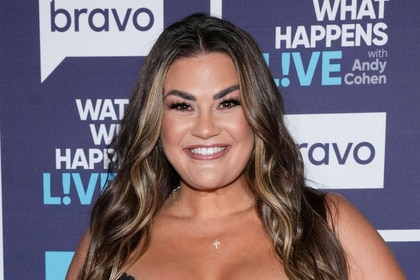 Brittany Cartwright posing in front of a step and repeat.