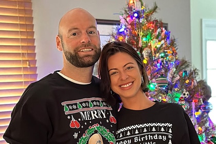 Chef Dave White standing with his wife in front of a Christmas tree