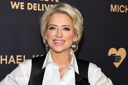 Dorinda Medley smiles wearing a white shirt and black vest