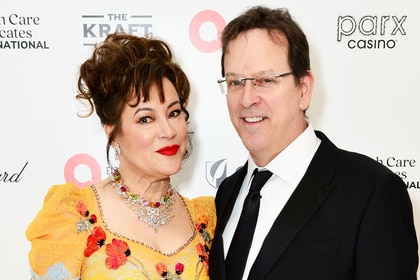 Jennifer Tilly and Phil Laak posing in front of a step and repeat.