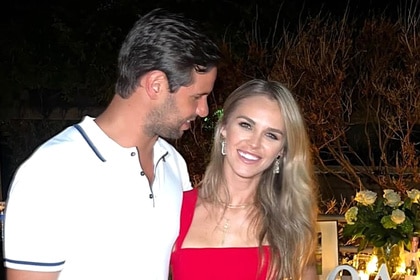 Olivia Flowers wears a red dress with her fiance at a party