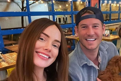 Austen Kroll and Kathryn Dennis smiling together at a restaurant.