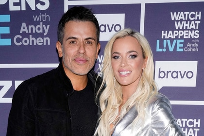 Teddi Mellencamp and Edwin Arroyave standing in front of the step and repeat at WWHL