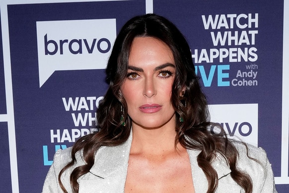 Katie Flood wearing a, crystal-embellished, 3 piece set in front of a step and repeat at the Watch What Happens Live clubhouse in New York City.