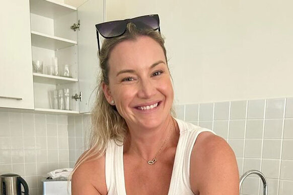 Hannah Ferrier wearing a white tank top in a kitchen.