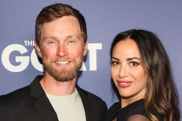 Luke Broderick and Kristen Doute smiling next to each other in front of a step and repeat.