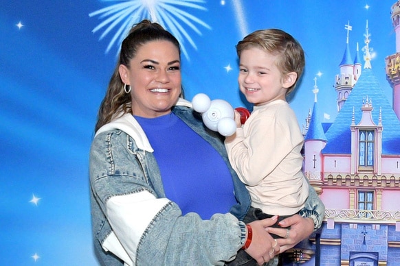 Brittany Cartwright and her son Cruz Cauchi in front of a Disney Castle image