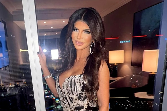 Teresa Giudice wearing a black and silver mini dress in front of a window.