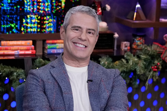 Andy Cohen smiles in a blue blazer on the set of Watch What Happens Live