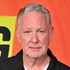 Paul Kemsley standing in front of a step and repeat.