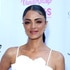 Golnesa Gharachedaghi on a red carpet wearing a white flower top