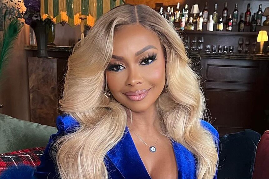 Phaedra Parks sitting on a couch and smiling.