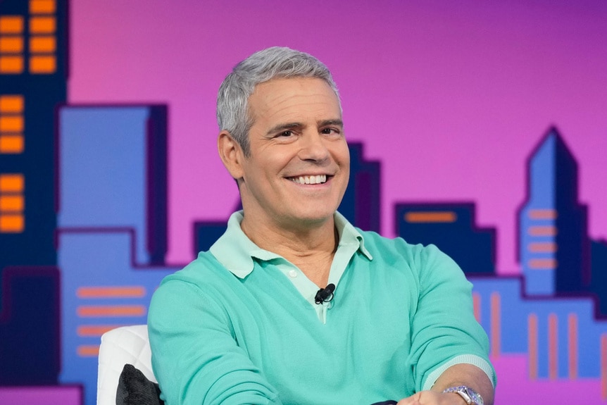 Andy Cohen smiling while onstage at Watch What Happens Live.