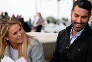 Olivia Flowers and Rod Razavi laughing together while on a date in a park.