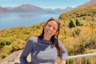 Aesha Scott smiling in front of a view of a mountain and a lake.