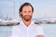 Iain MacLean wearing his yachting uniform on a boat marina
