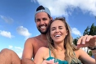 Olivia Flowers wearing a bathing suit and sitting with her boyfriend on a beach.