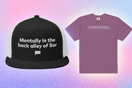 A mesh baseball cap and a purple tee on a pastel blue and pink background.