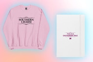 A pink Sweatshirt and white journal in front of a pink and peach background.