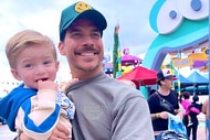 Jax Taylor holding his son Cruz Cauchi at an amusement park.