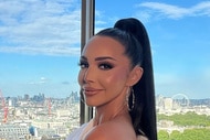 Scheana Shay smiling in front of a window with a view of London, England in full glam.