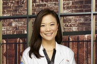 Shirley Chung smiling in front of a brick wall.