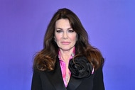 Lisa Vanderpump wearing a black blazer while standing in front of a blue backdrop