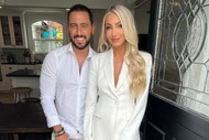 Josh Altman and his wife Heather Altman wearing white outfits in the door of their home.
