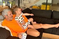 Andy Cohen and Lucy Cohen sitting on a couch watching TV