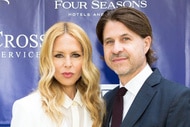 Rachel Zoe and Roger Berman posing together in front of a step and repeat.