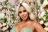 Mia Thornton posing in a mint green gown in front of a backdrop of flowers.