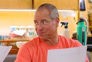 Captain Glenn wearing an orange tee shirt reading a preference sheet