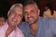 Mauricio Umansky hugging Eduardo Umansky and smiling.