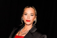 Teddi Mellencamp posing in a blazer and red outfit.