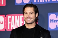 Craig Conover smiling in front of a step and repeat.