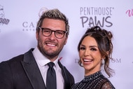 Scheana Shay and Brock Davies posing in front of a step and repeat.