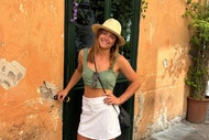 Malia White smiling in front of a doorway.