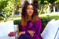 Noelle Robinson sitting outdoors while wearing a a purple dress