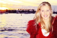 Gretchen Rossi in front of a harbor with boats at sunset
