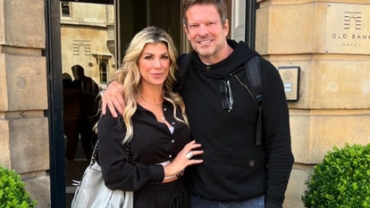 Alexis Bellino and John Janssen pose together outside of a hotel