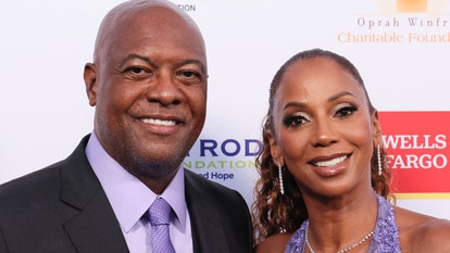 Holly Robinson Peete and Rodney Peete posing together on a step and repeat.