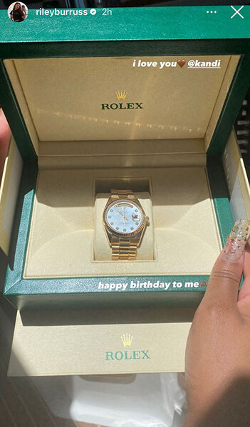 A gold watch inside of a green Rolex box.