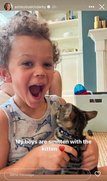 An image of Dean Darby holding a kitten and smiling.