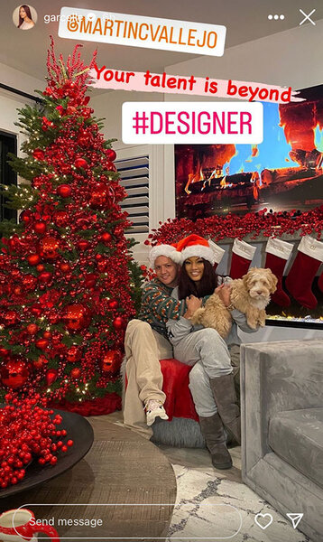 Garcelle Beauvais posing next to her Christmas tree and decor with her dog and a guest.