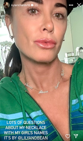 Kyle Richards wearing a gold necklace with her daughters names on it.